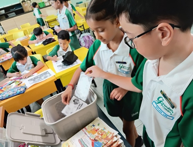 Students recycling paper as part of a classroom environmental activity.